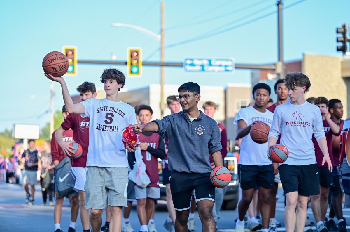 The State College Boys Basketball team makes its way through the parade. While some teams create new floats each year, boys basketball opts to keep their plan the same. The team puts a basketball hoop in the back of a truck, encouraging parade-goers to shoot hoops from the curb. "I love every time someone makes a shot. Everyone [on the team] would hype them up. It created a really fun atmosphere," sophomore Chase Rhodes said on the tradition.