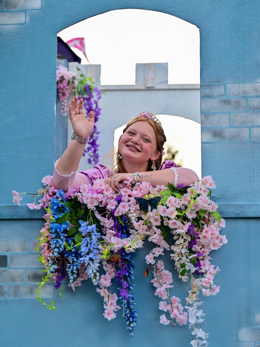 Senior Delaney Shaha waves from her position on the State College Field Hockey float. The field hockey team chose to make a Disney-themed float, and captured second place in the competition behind girls volleyball. 