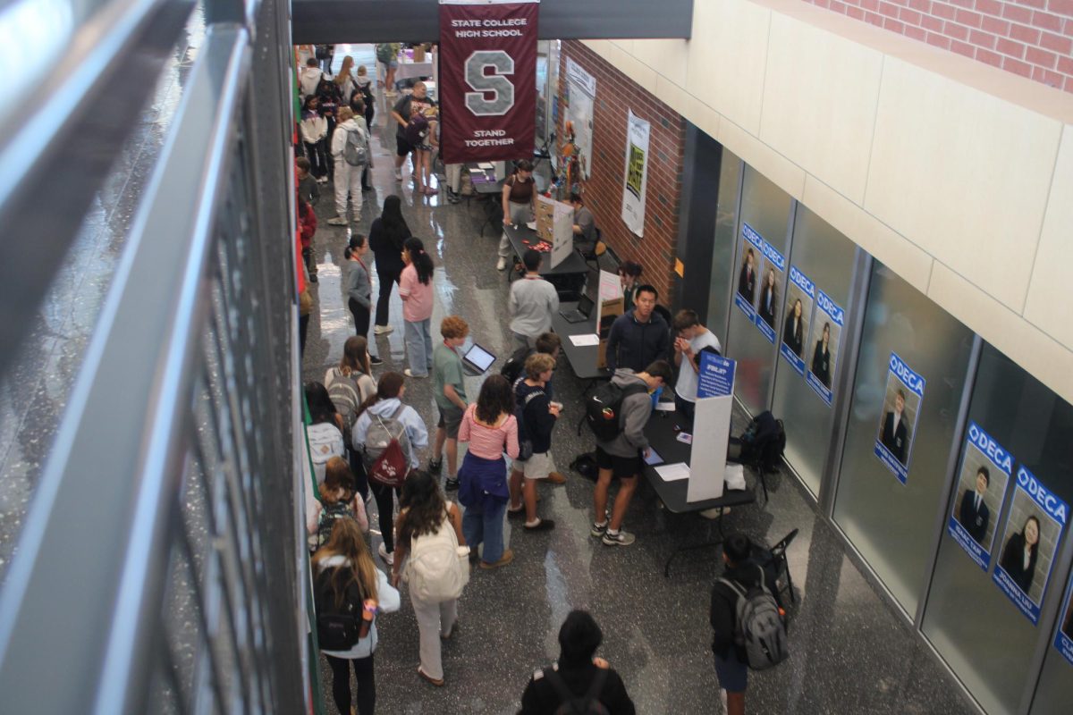 A crowd of students walking in the hall, stopping at posters to read about SCAHS's club opportunities.