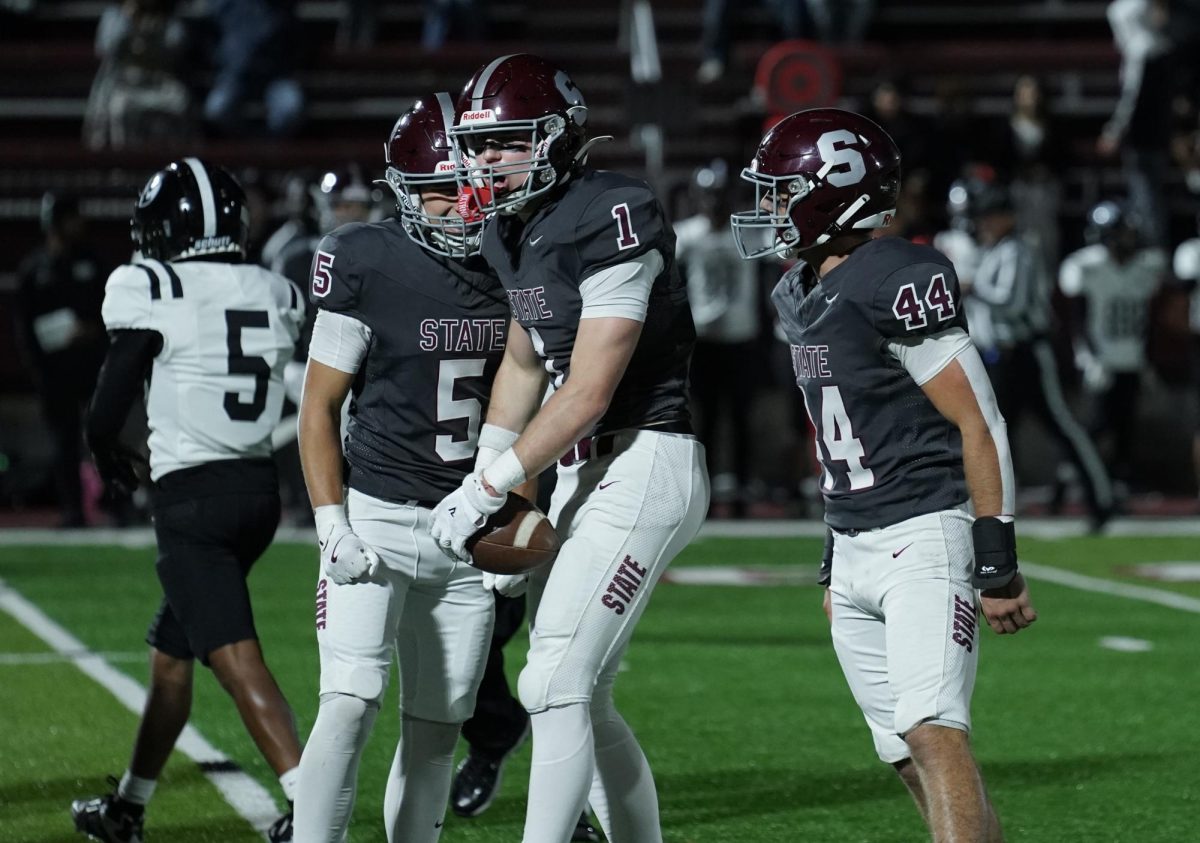 Junior Kellen Williams, junior AJ Fry and senior Trayce Brennan celebrate Fry's second interception of the game.
