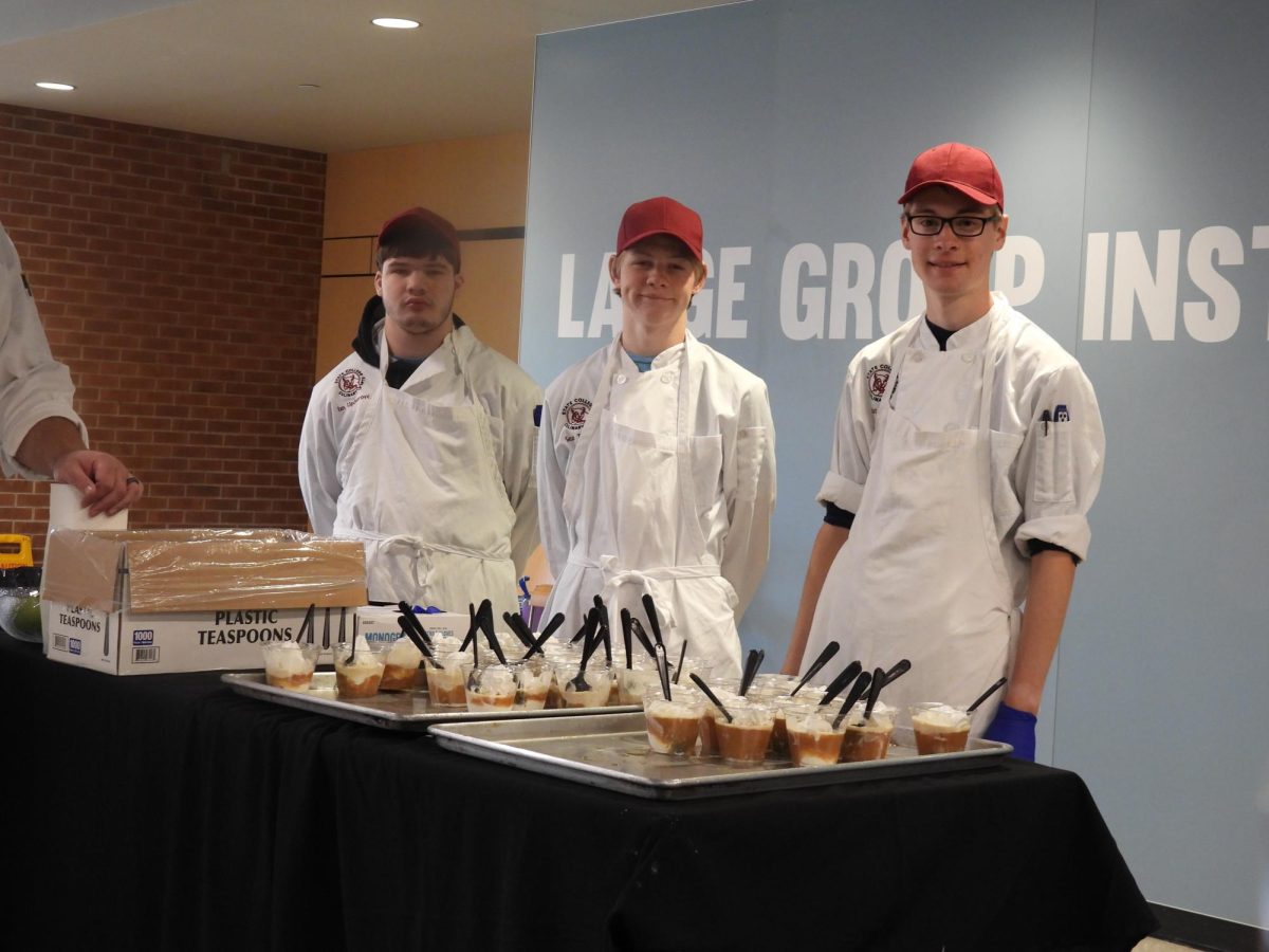 (From left to right) Culinary Arts students Ian Updegrove, Sean Telfer, and Nate Diehl give out apple cider and vanilla ice cream floats to students.