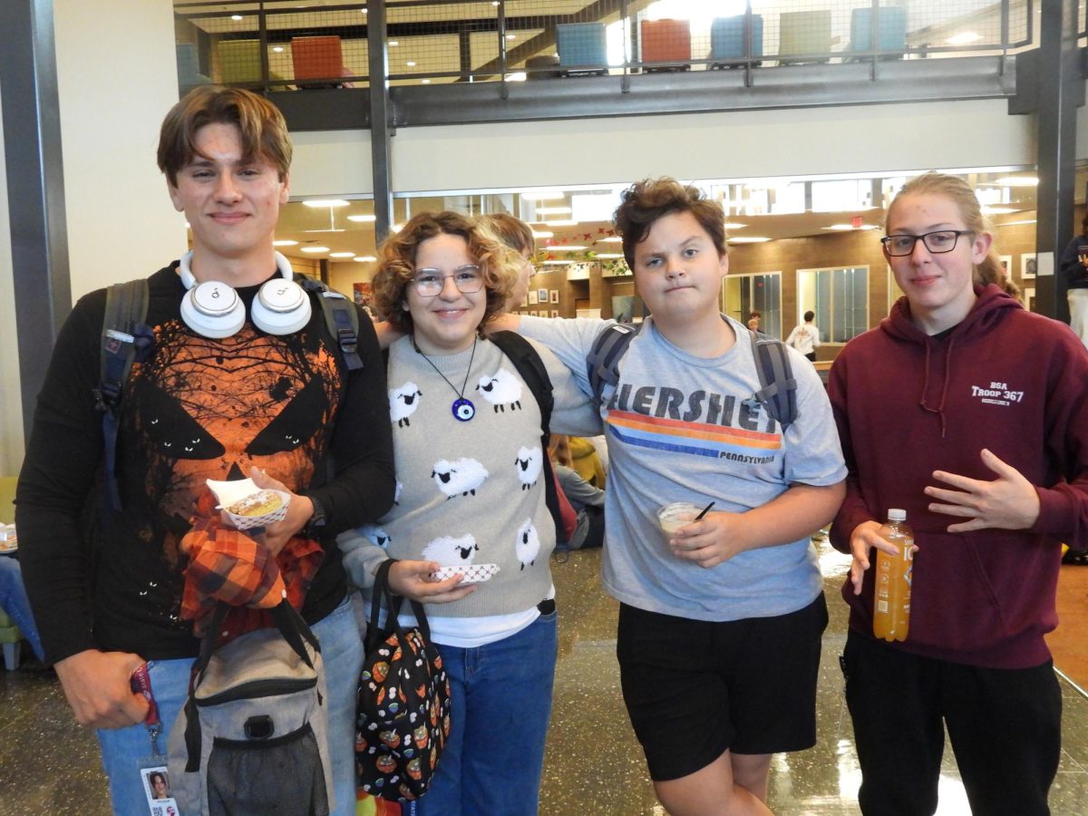 (From left to right) Senior Ethan Swauger, sophomore Ezra Manias, sophomore Jacob Heller, and junior Declan McGinnis enjoy the fall treats offered at the festival, like apples and ice cream.