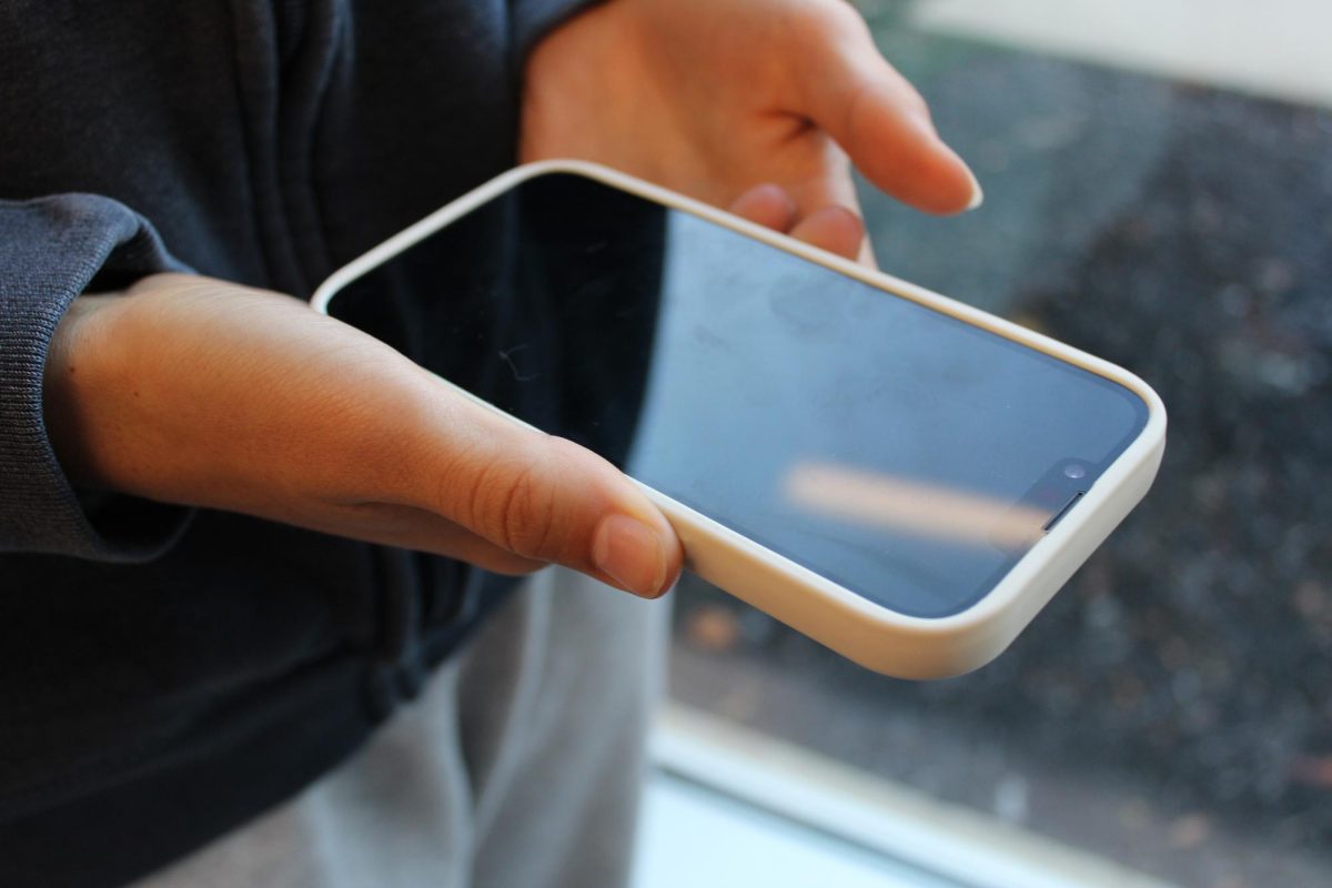 A student holds a cell phone.