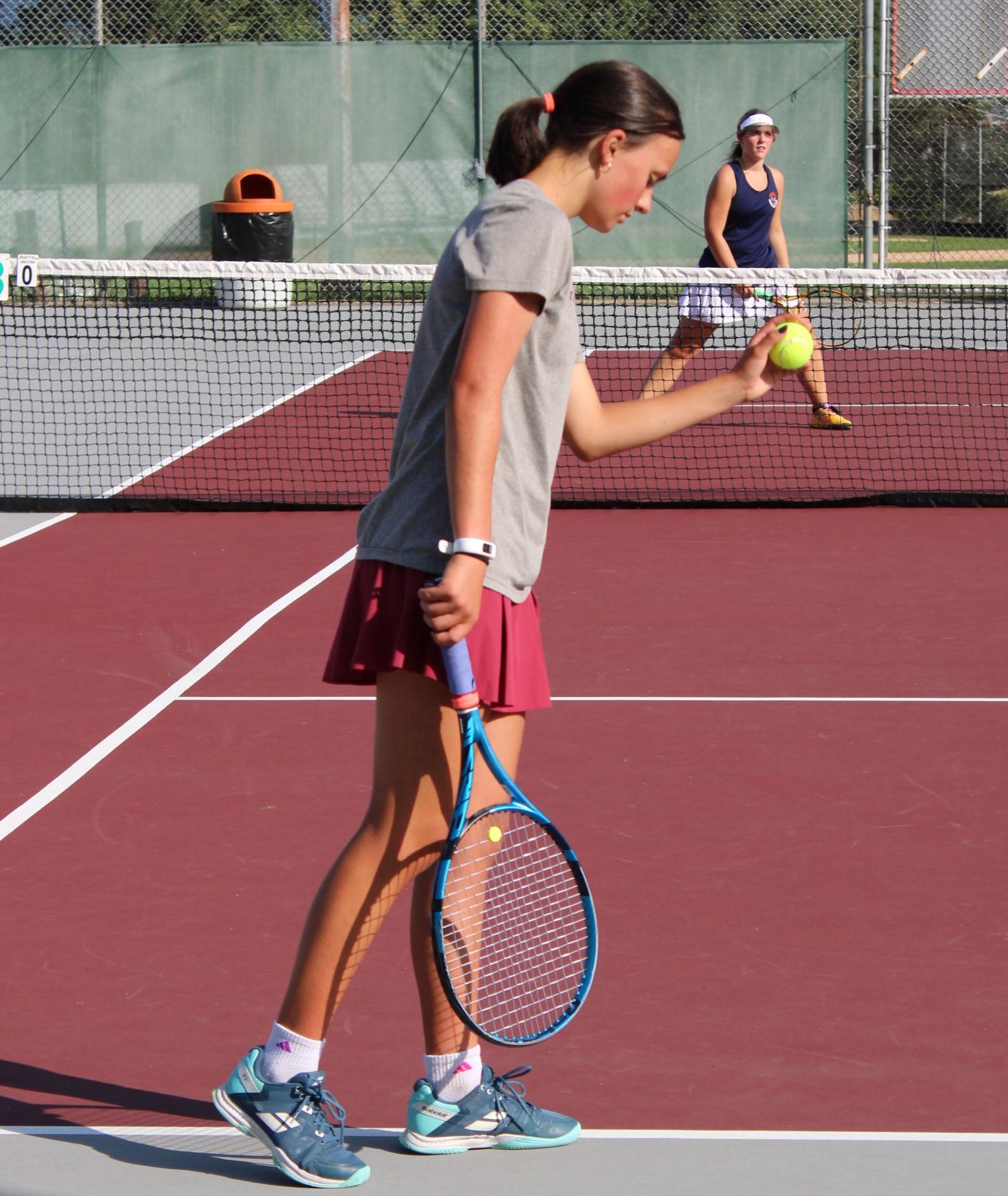 Senior Kazie Dingwell serves in a match at the Community Field Courts.