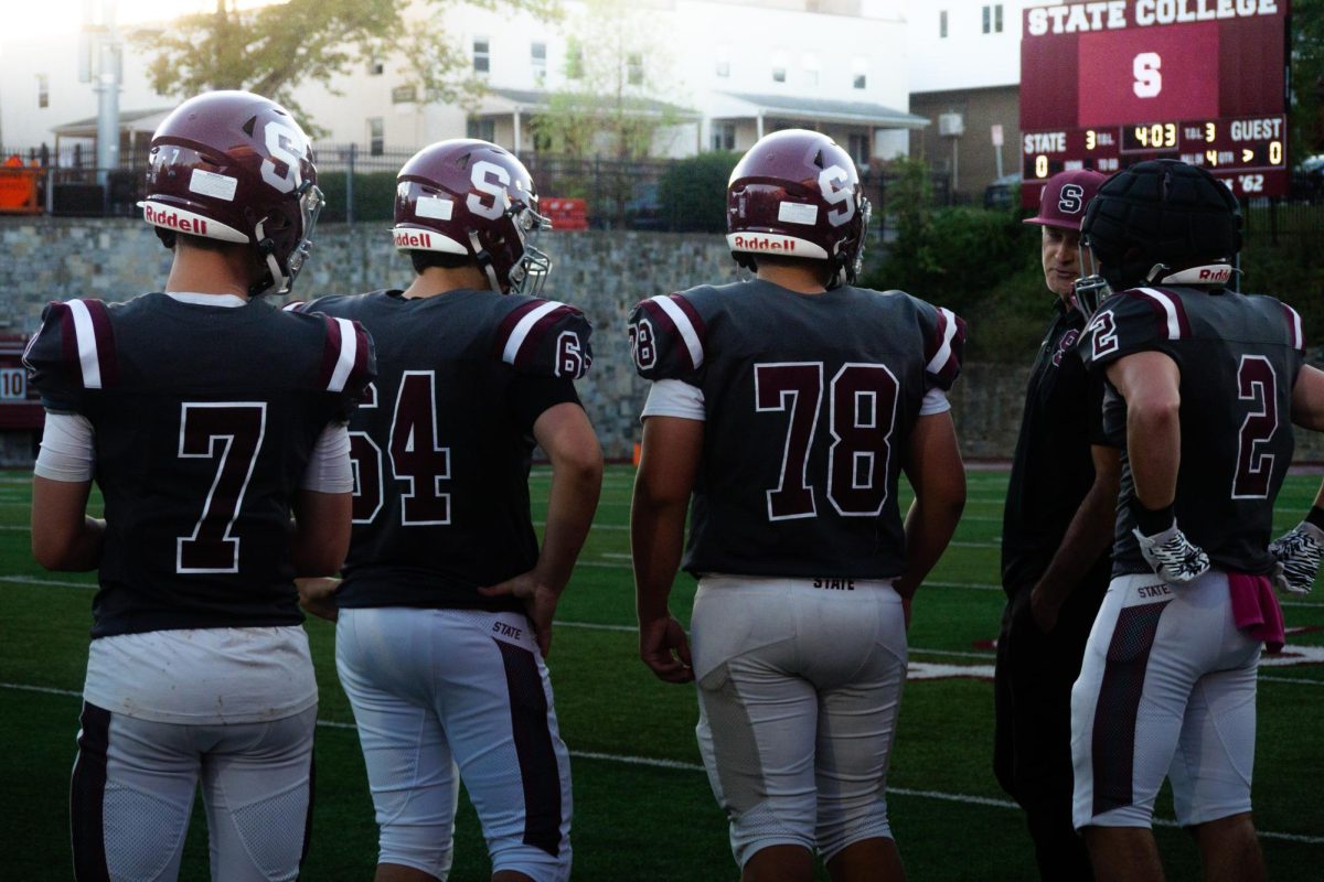 Team Captains, Gavin Mutnan, Nate Cruz, Zeke Gagliardi, and Wesley Shippert talking with Head Coach Robert Furmanek before walking out for the coin toss.
