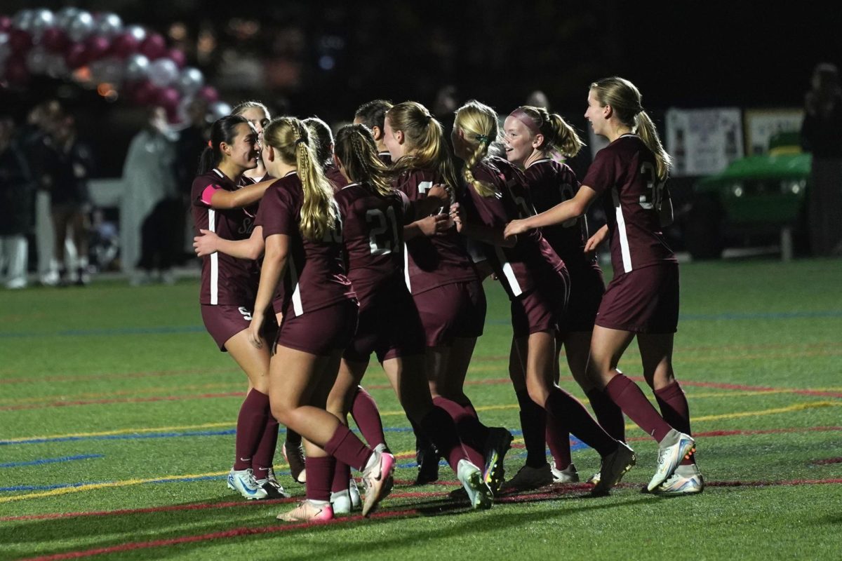 The team celebrates after senior Maya Birkenholtz scores a goal.