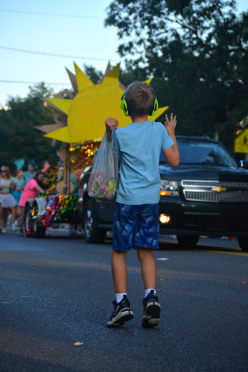 A child hops in anticipation as more students approach to top off his brimming bag of candy. There was a strong presence of children who attended the parade with their families, and these children went home with enough candy to feed the entirety of their extended families.