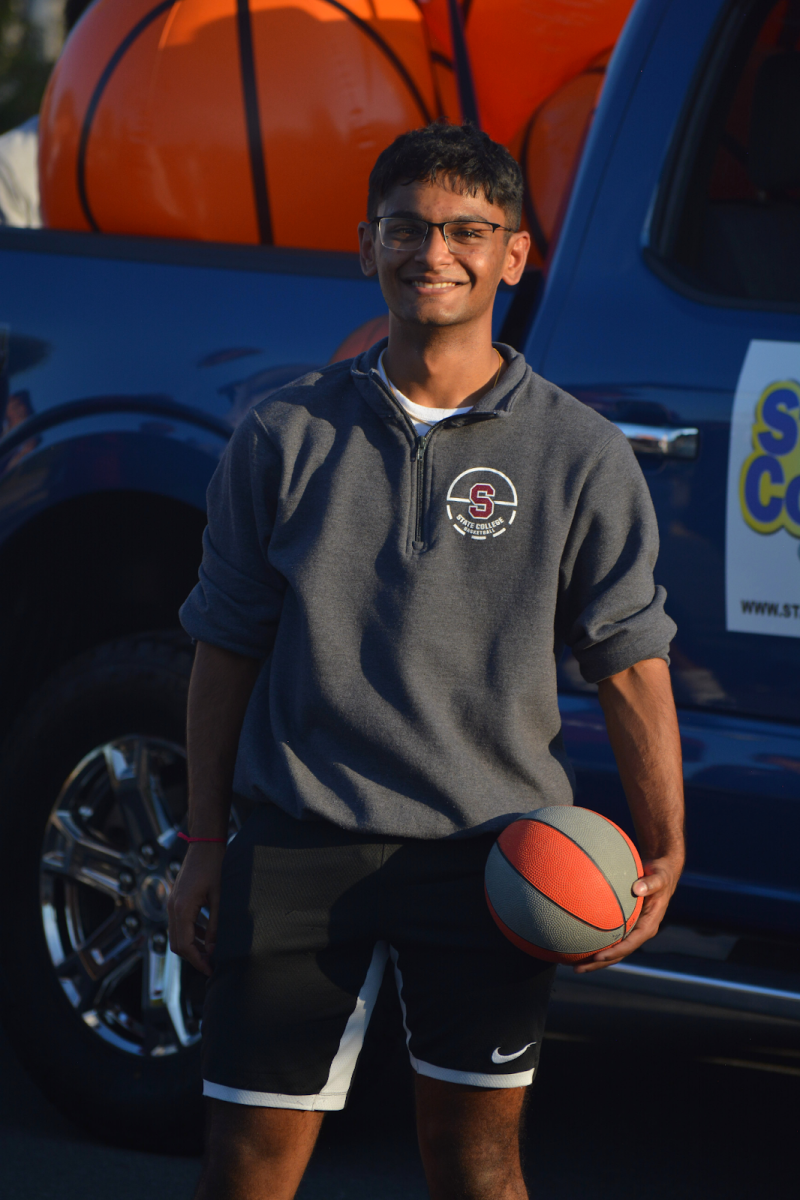 Basketball player and senior Veer Patel holds a basketball as he smiles into the camera. Patel talked about how important the parade meant to him, saying, “Being a senior, it has been an amazing experience during the homecoming parade; it has allowed me to reflect on the past four years…It was a very nice moment to just enjoy being with my friends from basketball for a final time.”