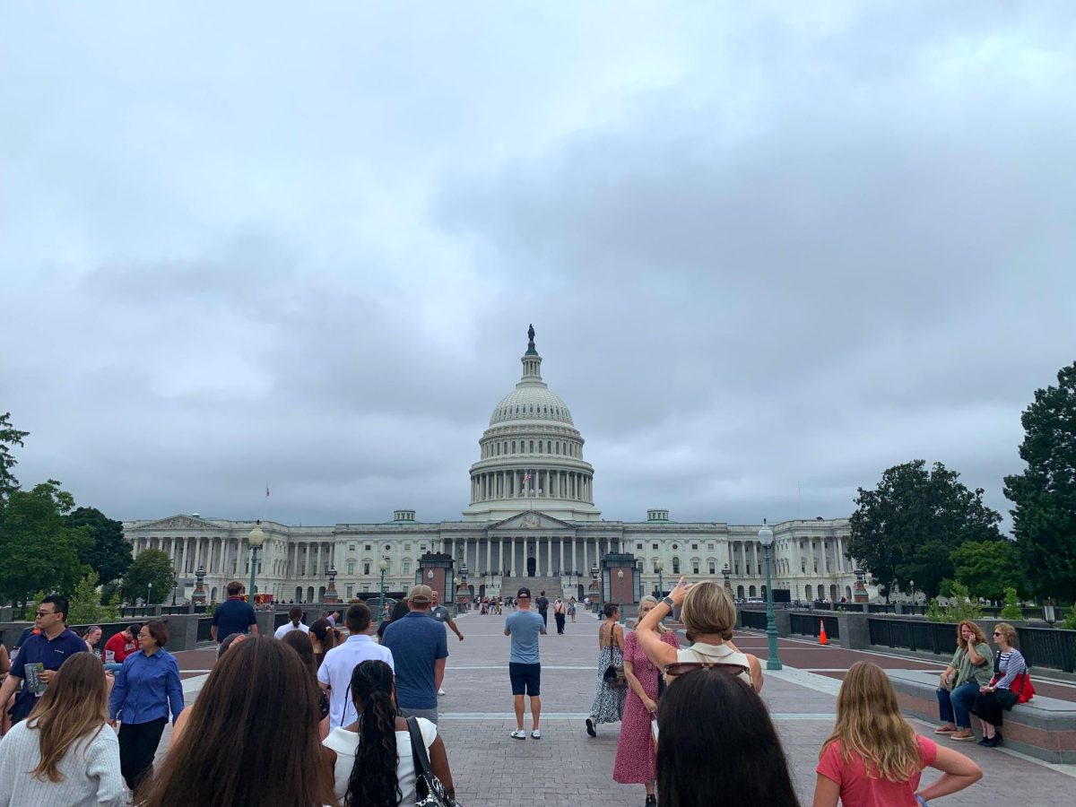 Tourists walk toward the U.S. Capitol Building on a stormy day in Washington, DC.
