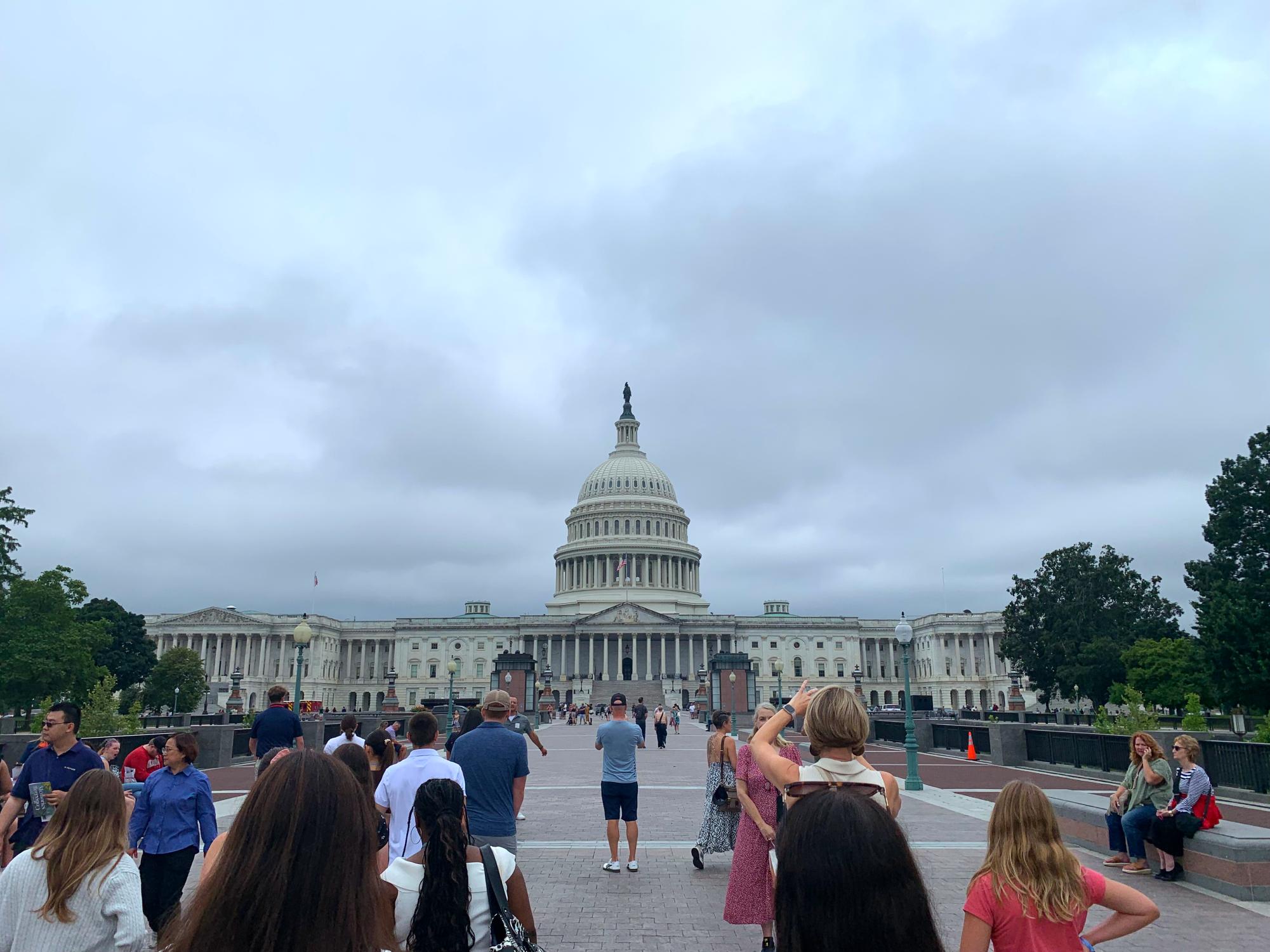 Tourists walk toward the U.S. Capitol Building on a stormy day in Washington, DC.