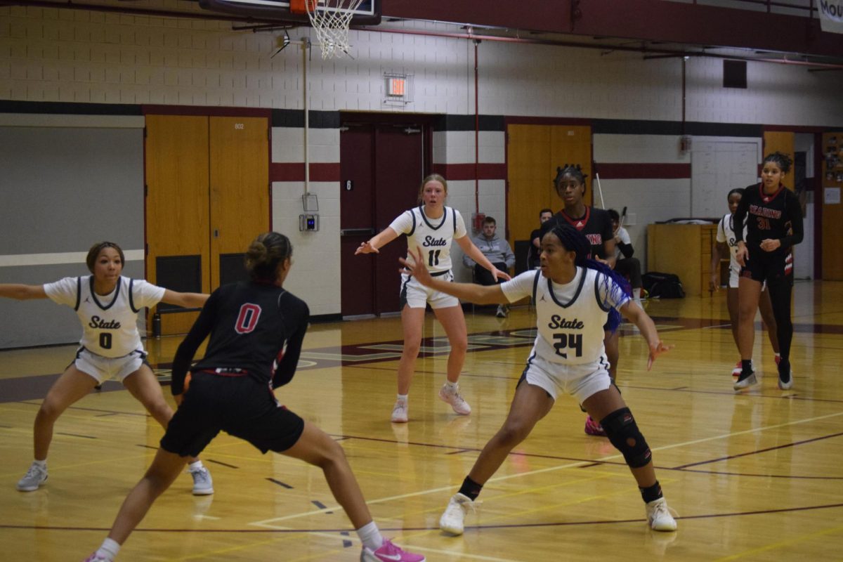 Sophomores Desaray Mobley, Ally Swauger, and junior Sienna Wilson defend a Reading guard.