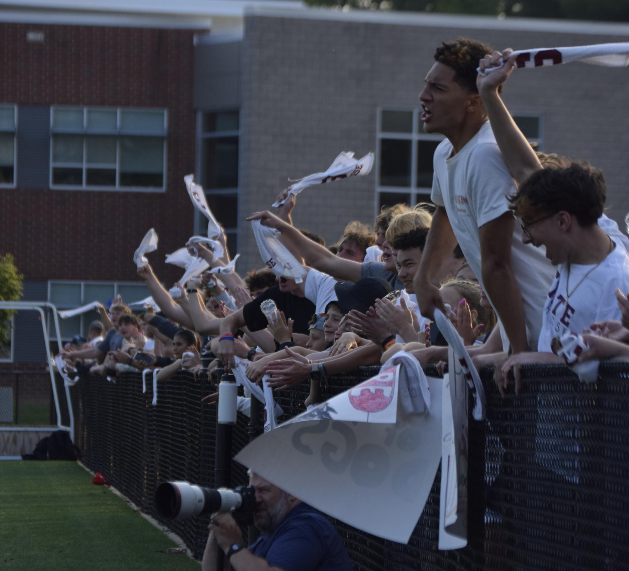 State High students line the fence at the North Turf to cheer on the boys lacrosse team in a state playoff game.
