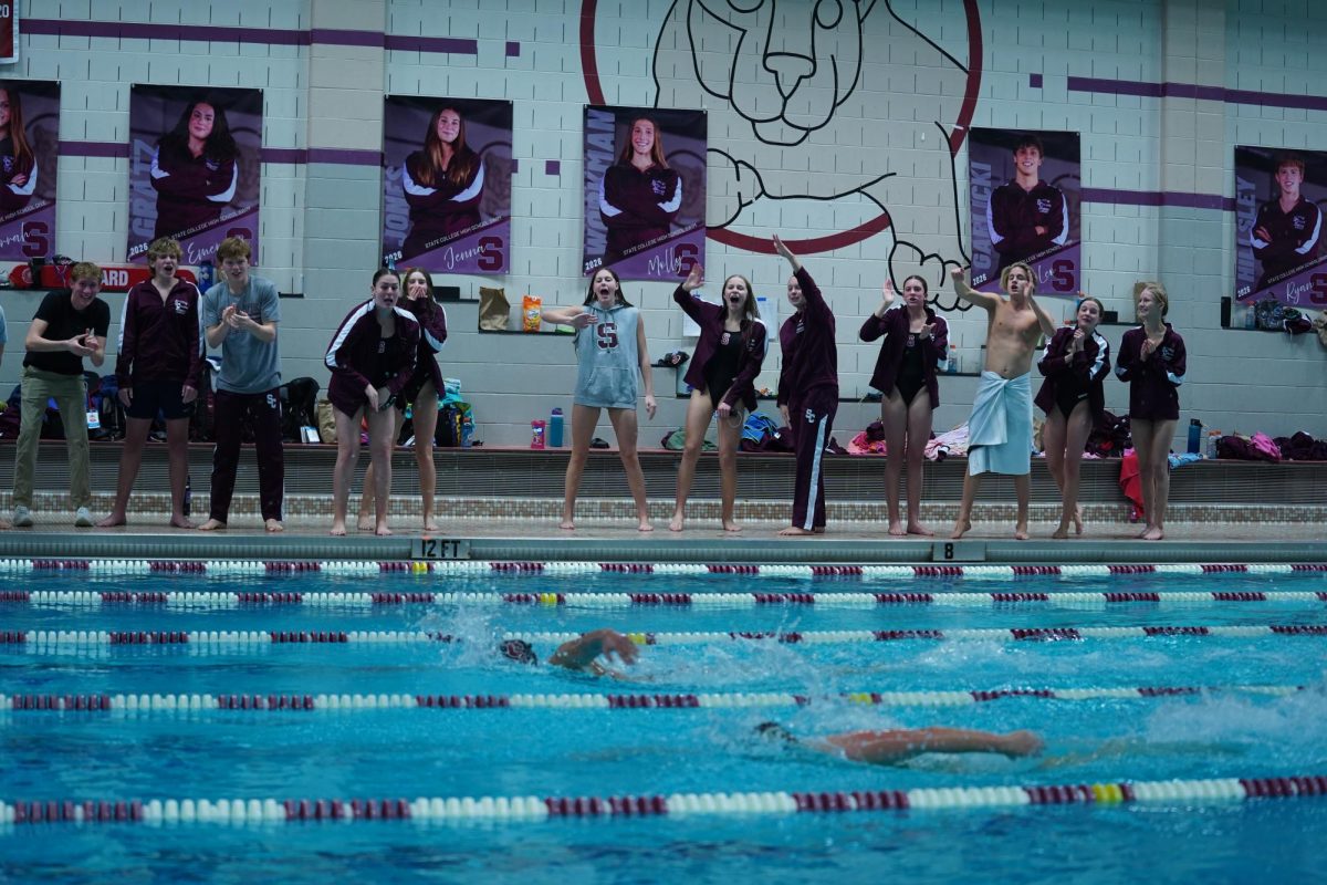 A State High swimmer is edging ahead of a Carlisle swimmer as they finish towards the wall, State High swimmers cheer on to push their teammate for the win. “I was trying to create a exciting and hype environment that can to fast swims and better times overall,” sophomore Adam Huggins said. The encouragement definitely impacted the Little Lions' domination of the Bison at home.
