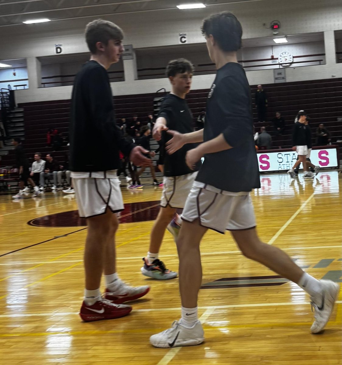 Senior Michael Powell high fives senior Parker Thurley and junior JJ Powell during warmups