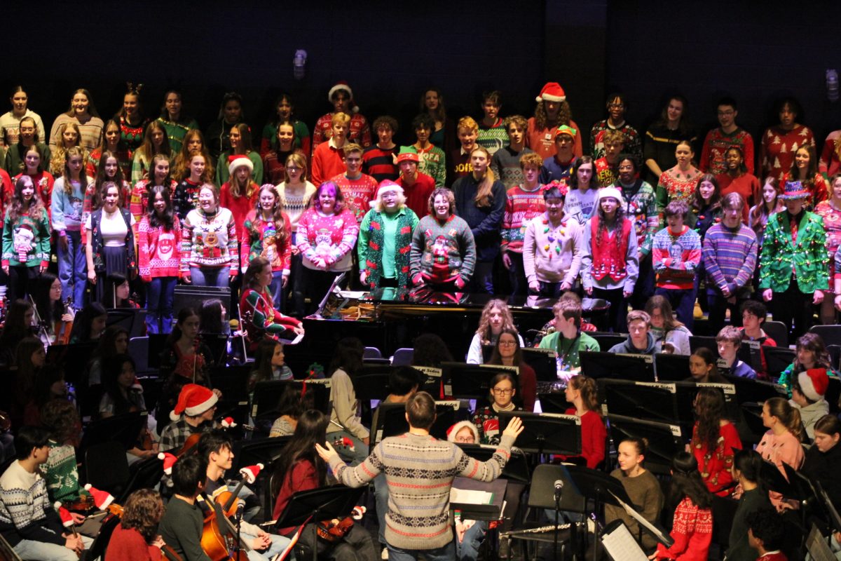 Erik Clayton directs the combined choir as they sing “Have Yourself a Merry Little Christmas.”