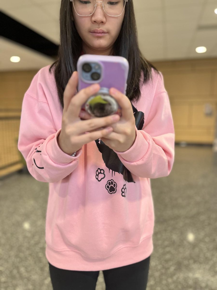 Kylie Matsueda poses for a photo while using her phone during the school day. 
