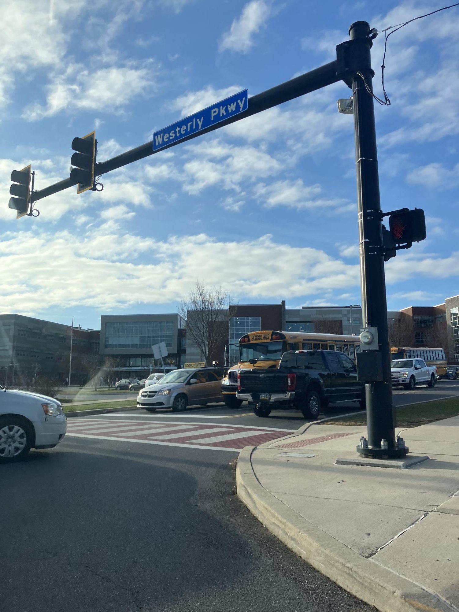 The crosswalk stands facing towards State High as cars drive by.