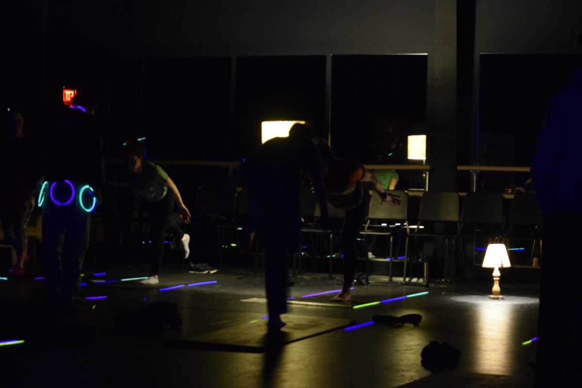 Physical education teachers, Jennifer Eaton, Nicole Miller, and Courtney Morrison lead a yoga session during the spring mental health summit. “Doing it in the dark makes people more comfortable because they don’t see others in discomfort or themselves, so they’re more willing to be in poses that may feel weird and look weird,” said Eaton.