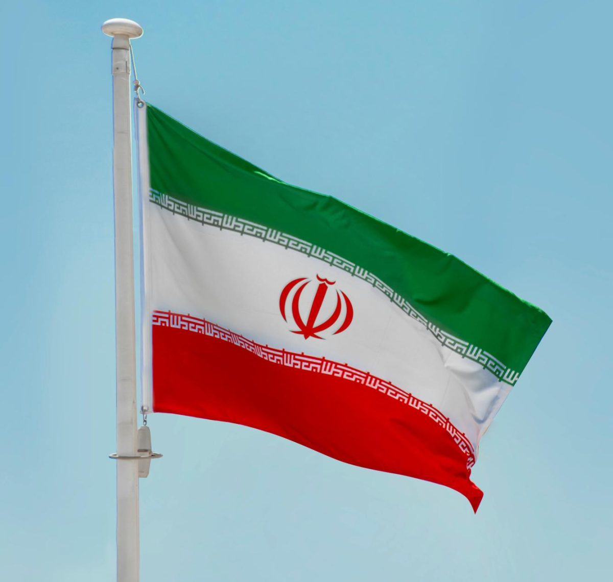 The Iranian flag flies high, backed by a clear blue sky on Aug. 27, 2022. Photo Credits: Aboodi Vesakaran