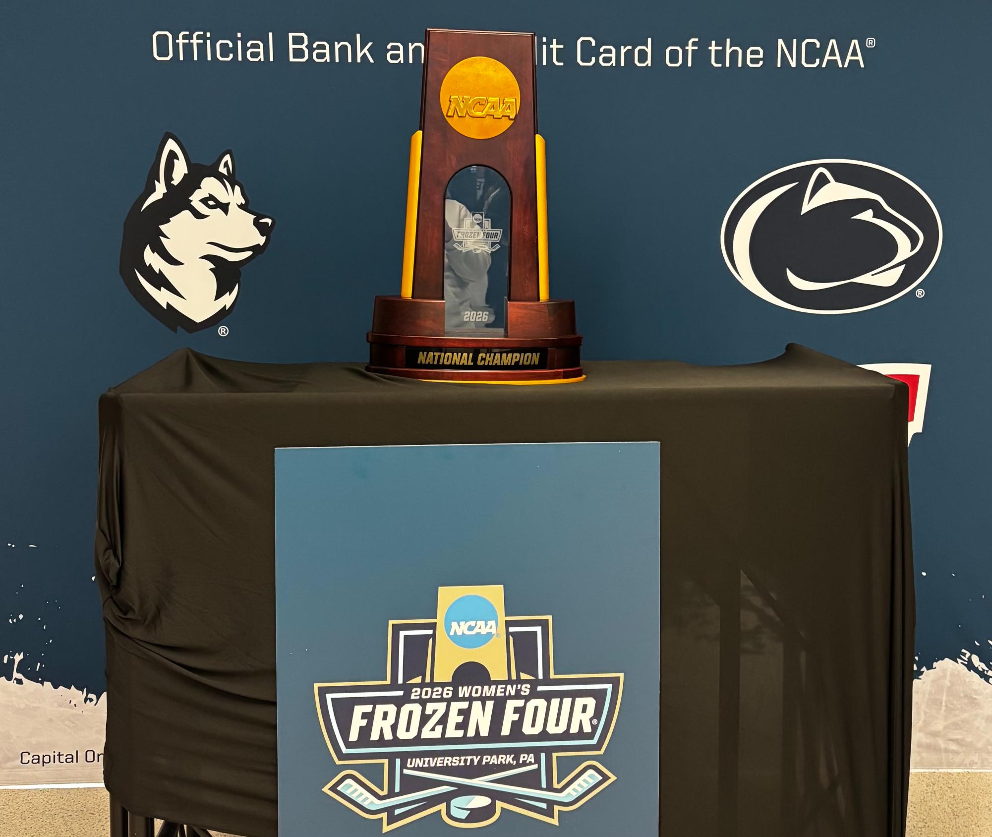 The national championship trophy sits with the Frozen Four logo in Pegula Ice Arena.