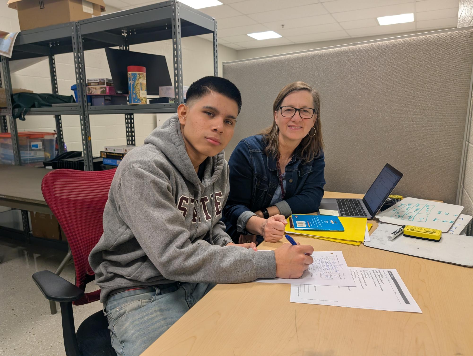 Janet Lenze helping a student with school work, photo taken by Lynn Fry
