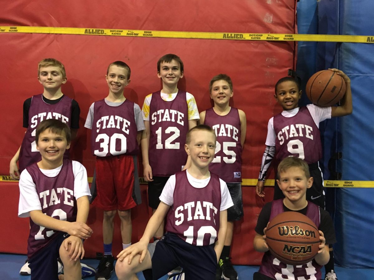 Michael Powell (30) poses for a photo with his youth basketball team, BARF.