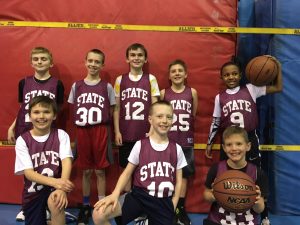 Michael Powell (30) poses for a photo with his youth basketball team, BARF.