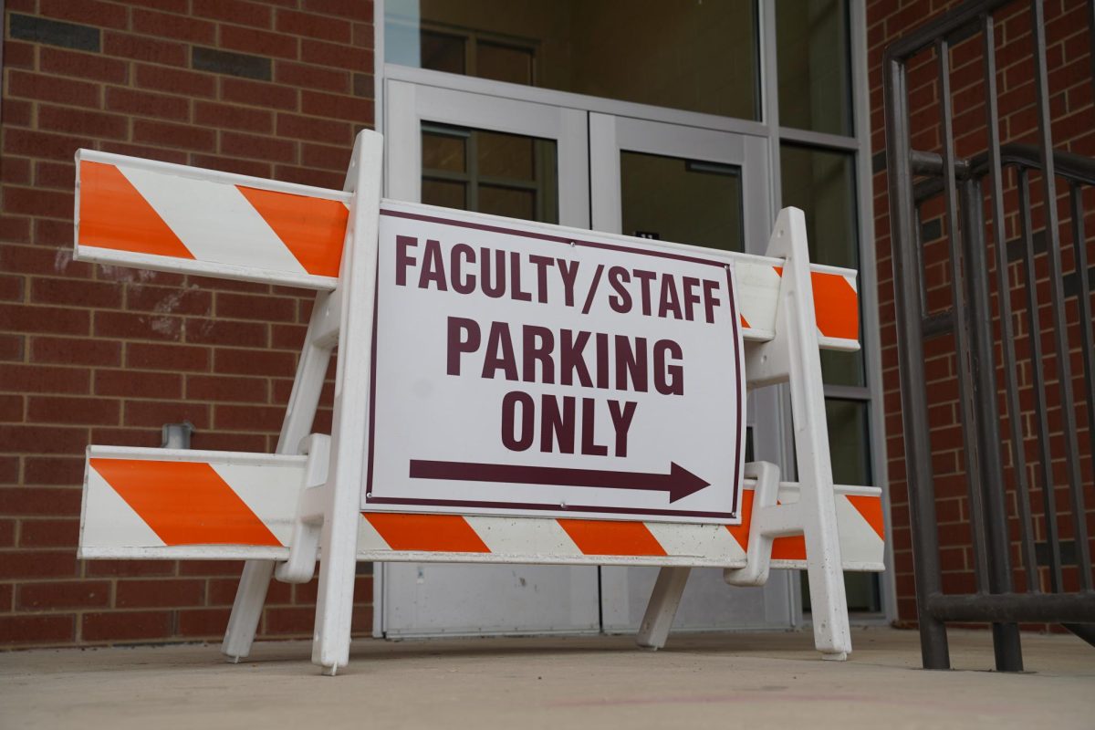 A barrier with a sign that reads "Faculty/Staff Parking Only" sits outside an entrance to State High.