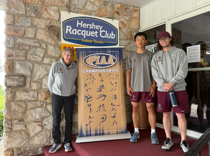 A photo features (from left to right) Jane Borden, William Liu and Ryan Kennedy in front of the PIAA championship sign. 
