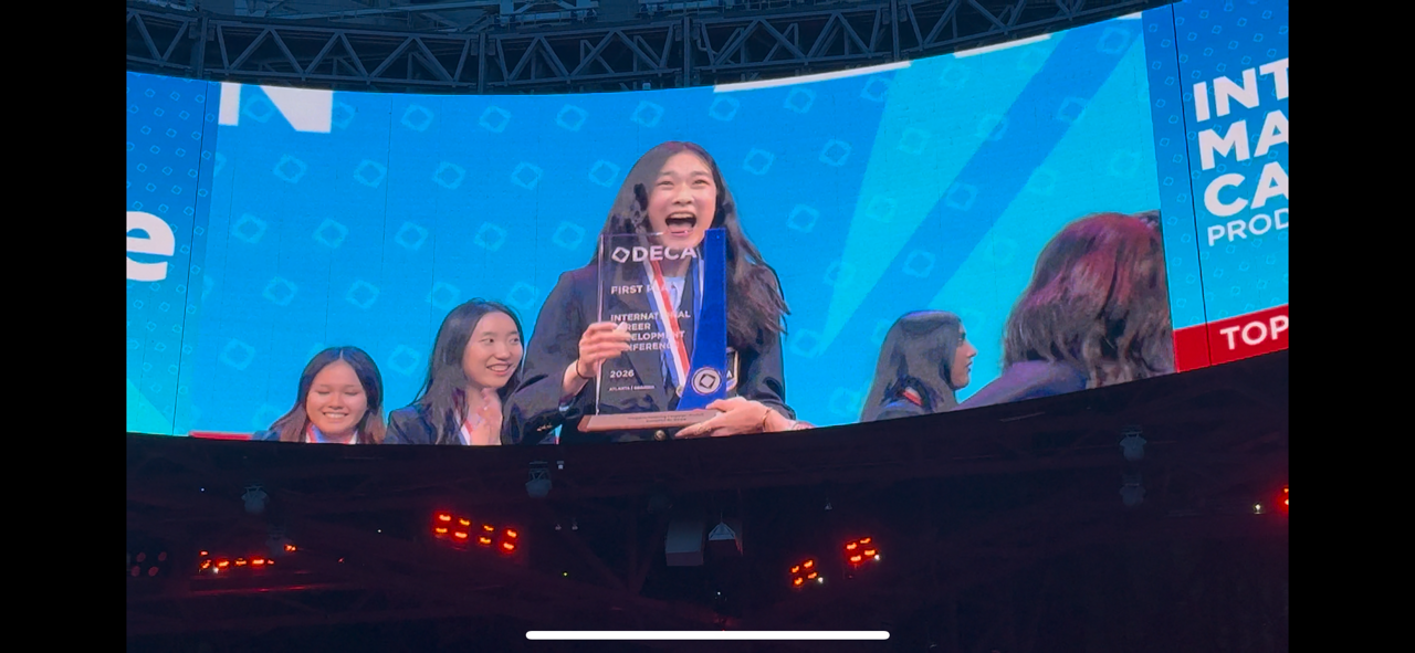 Sophomore Olivia Li is featured on the video board at Mercedes-Benz Stadium after receiving her trophy for State High's first DECA world championship.

Photo Courtesy of Bridget Ciolkosz